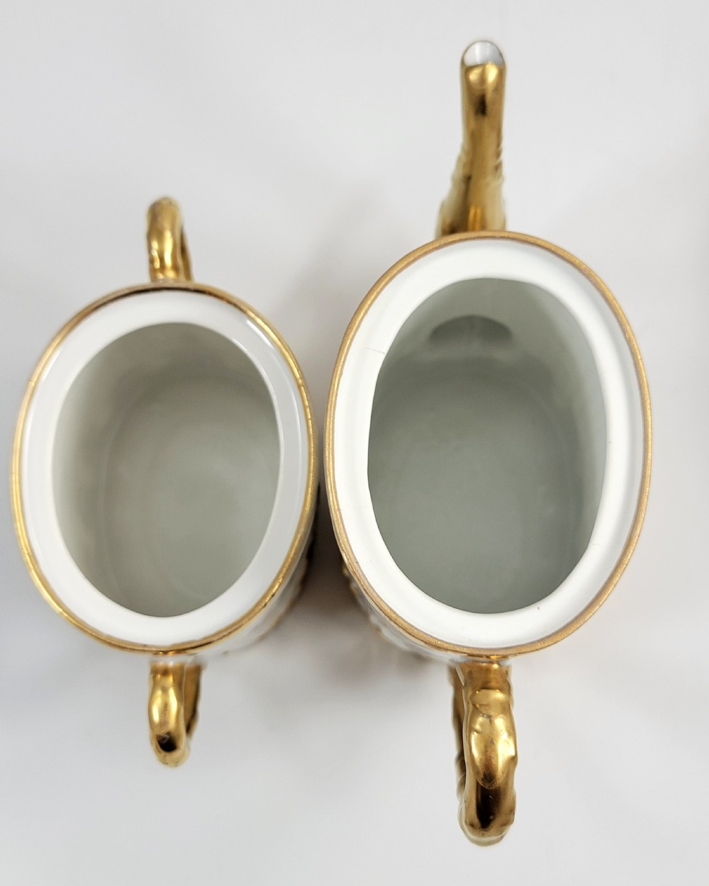A three-piece white porcelain coffee set featuring a pot, sugar bowl, and cream jug with fluted bodies and gilded acanthus leaf detailing. View VII
