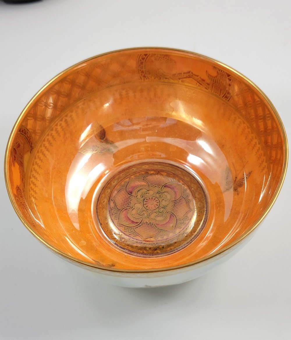 A rounded ceramic lustreware bowl featuring polychrome butterfly illustrations on an iridescent white exterior and an orange gilded interior. View VIII