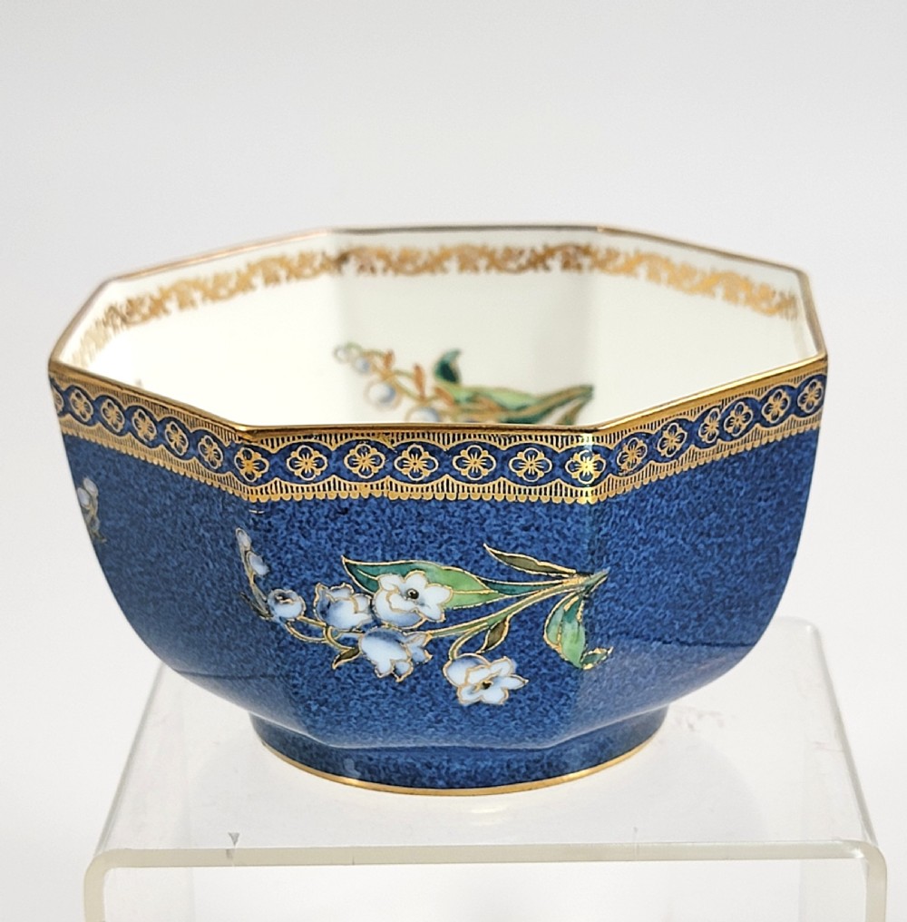 An octagonal Wedgwood lustre porcelain bowl featuring a blue mottled exterior adorned with hand-painted floral motifs and gilt borders.