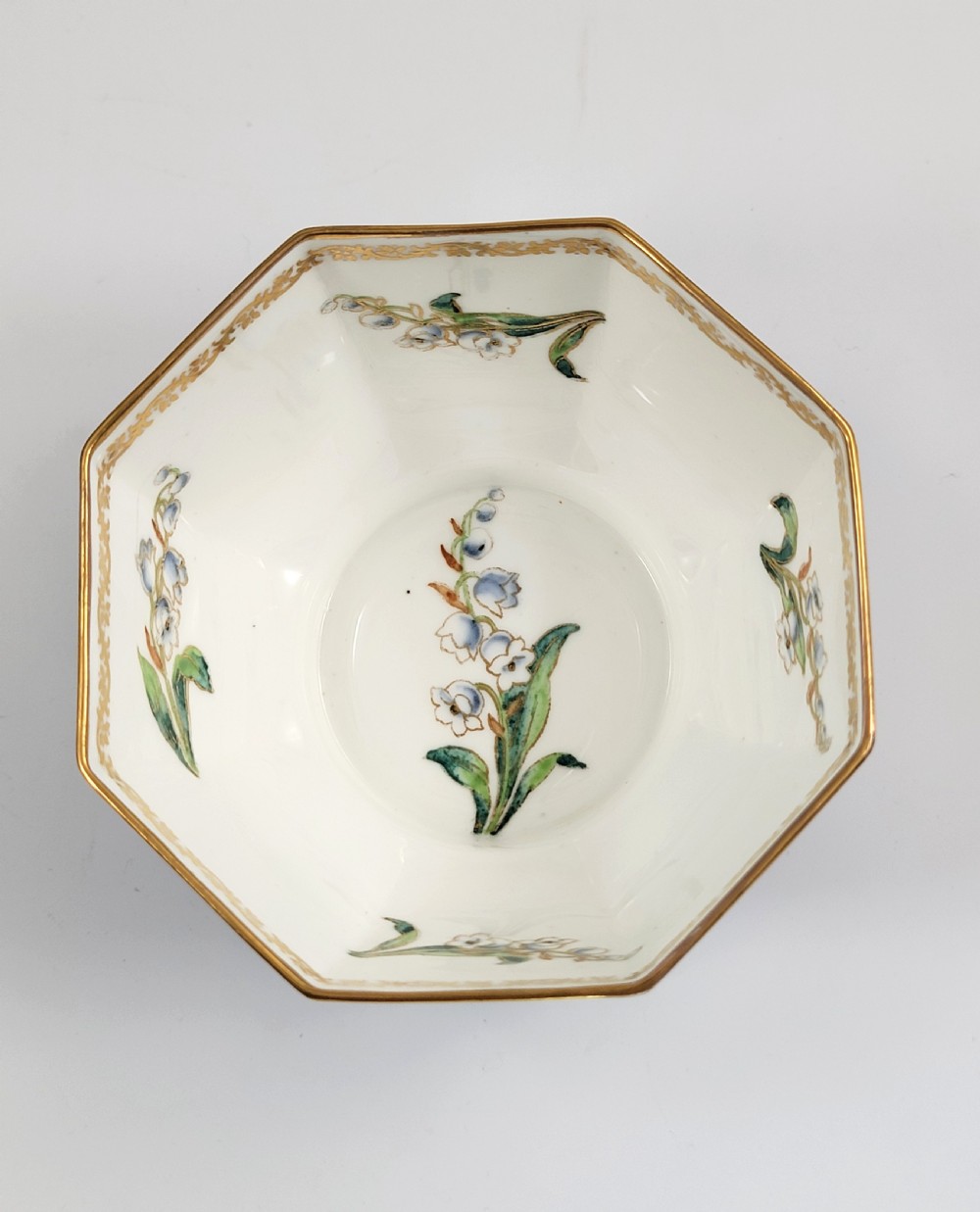 An octagonal Wedgwood lustre porcelain bowl featuring a blue mottled exterior adorned with hand-painted floral motifs and gilt borders. View VI