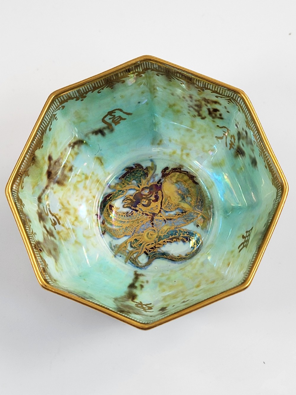 An octagonal antique Wedgwood lustre bowl featuring an iridescent purple exterior with gold gilded motifs and a pale green interior. View VIII
