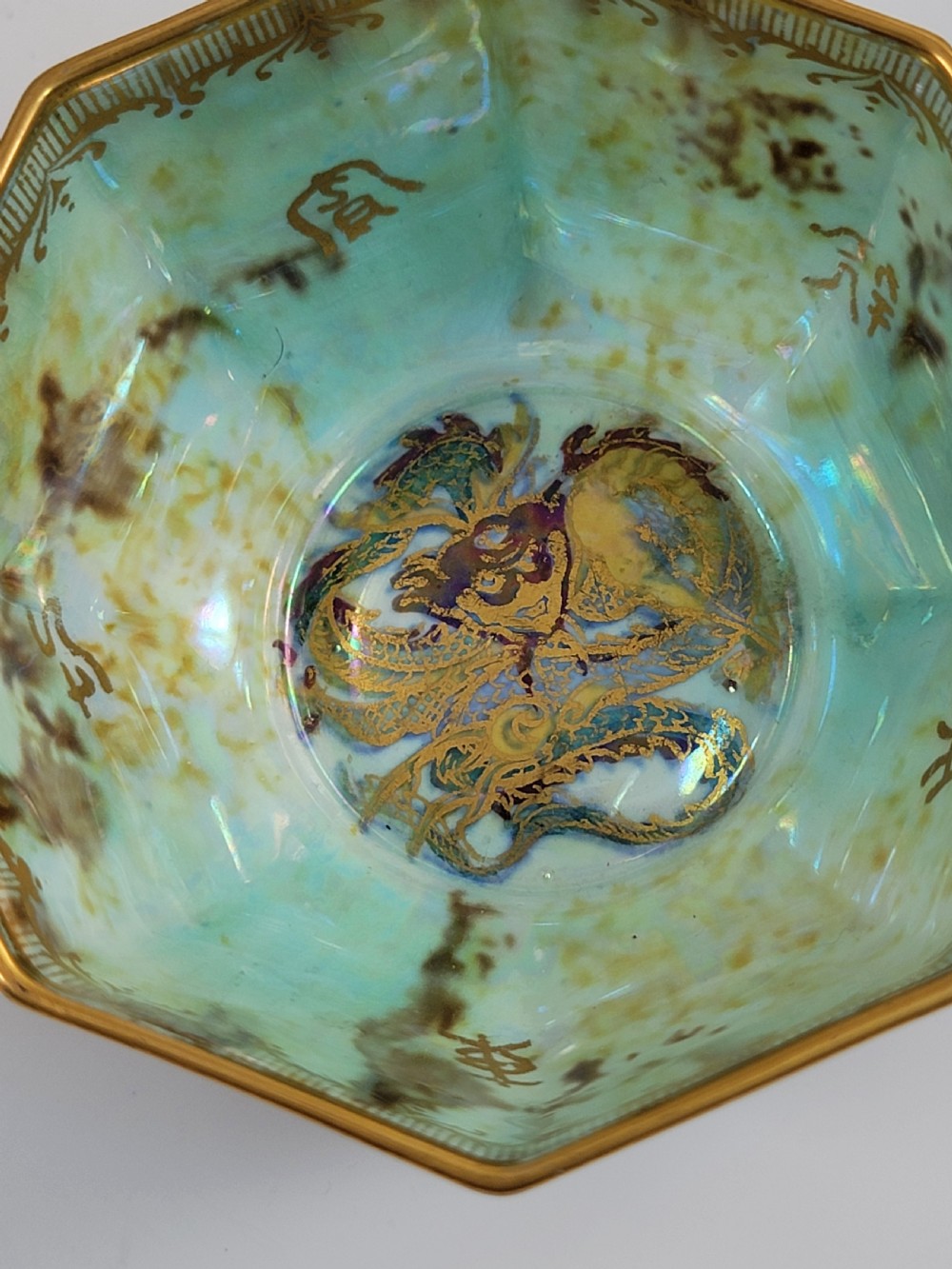 An octagonal antique Wedgwood lustre bowl featuring an iridescent purple exterior with gold gilded motifs and a pale green interior. View IX