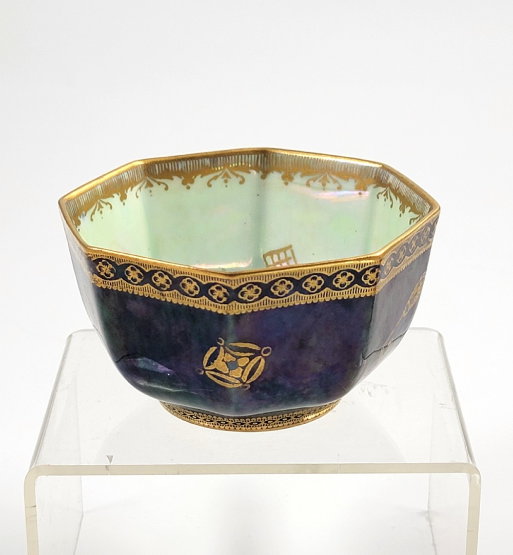 An octagonal porcelain bowl featuring a deep blue iridescent exterior with gilt line drawings and a pale green pearlescent interior. View II