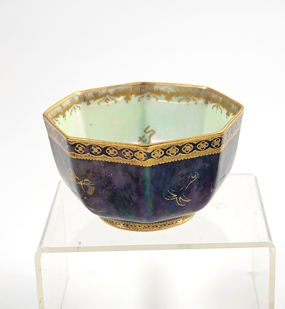 An octagonal porcelain bowl featuring a deep blue iridescent exterior with gilt line drawings and a pale green pearlescent interior. View V