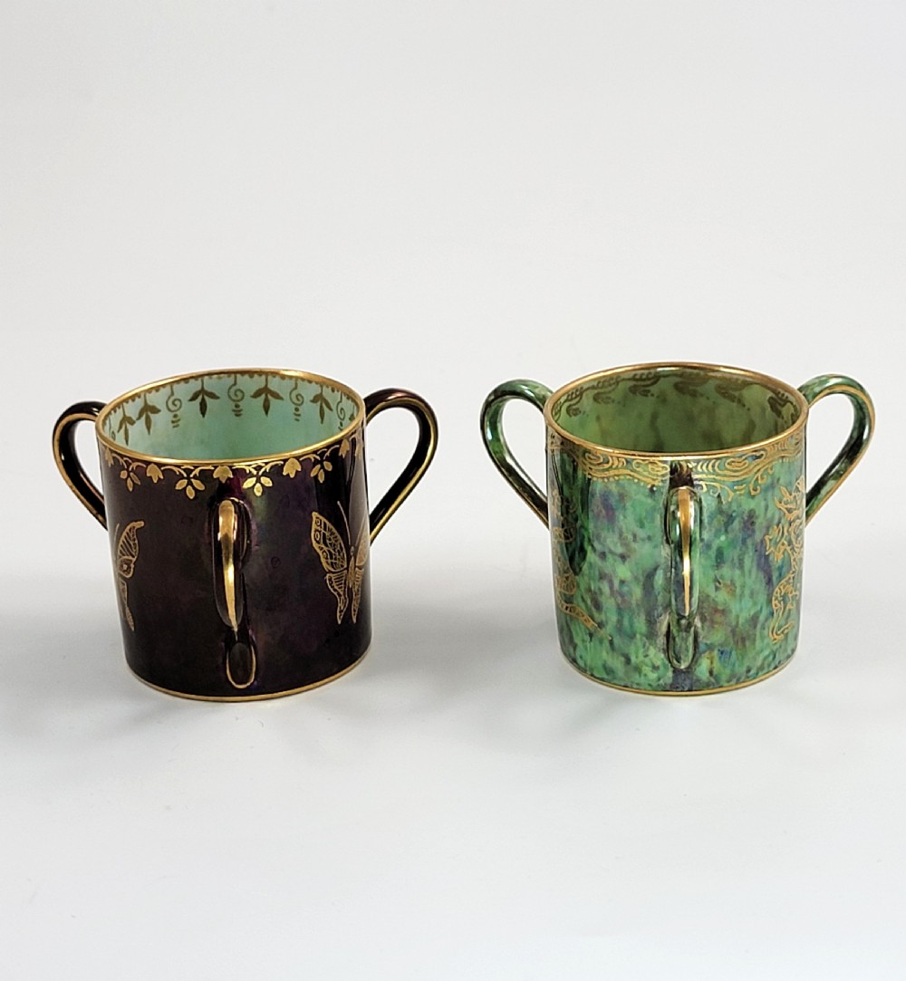 A pair of small three-handled ceramic cups, one in deep purple with a gilded butterfly design and the other in iridescent green with a gilded snake motif. View II