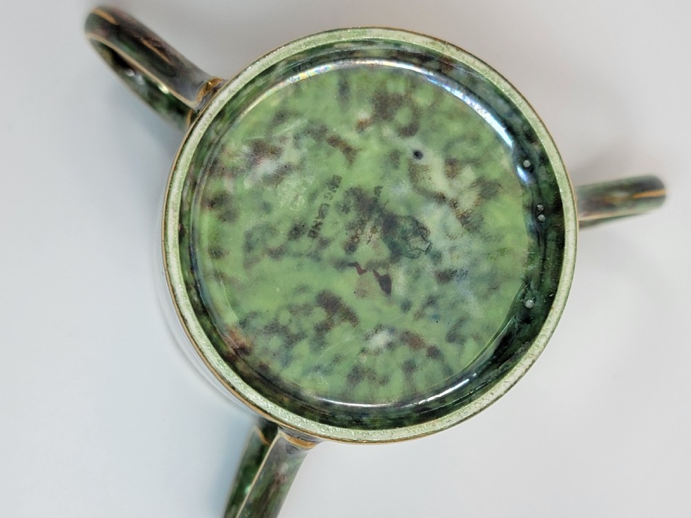 A pair of small three-handled ceramic cups, one in deep purple with a gilded butterfly design and the other in iridescent green with a gilded snake motif. View VII