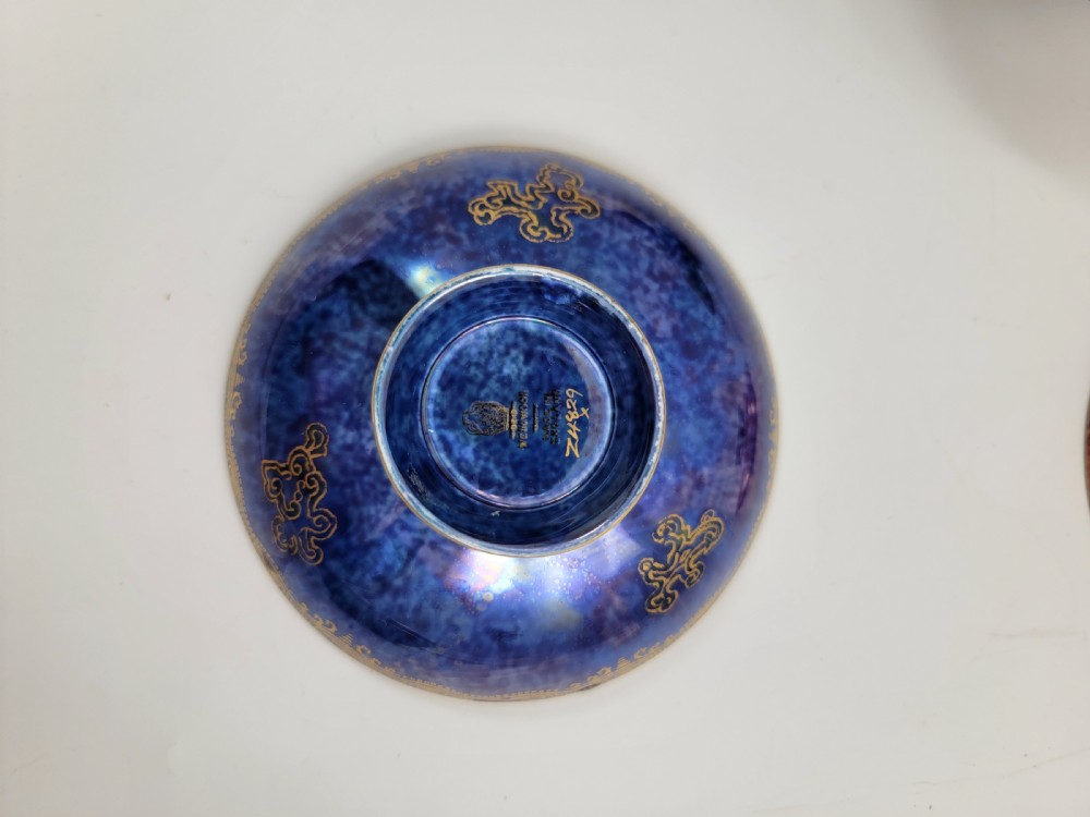 A set of three miniature footed porcelain bowls featuring iridescent lustre glazes in shades of blue, orange, and turquoise, embellished with gilded rim details and central motifs. View VII