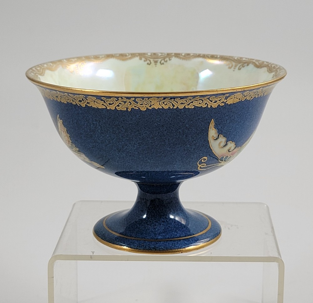 A footed Wedgwood porcelain bowl featuring a deep blue mottled exterior embellished with a gilded butterfly and an iridescent pearlescent interior with gold trim. View II