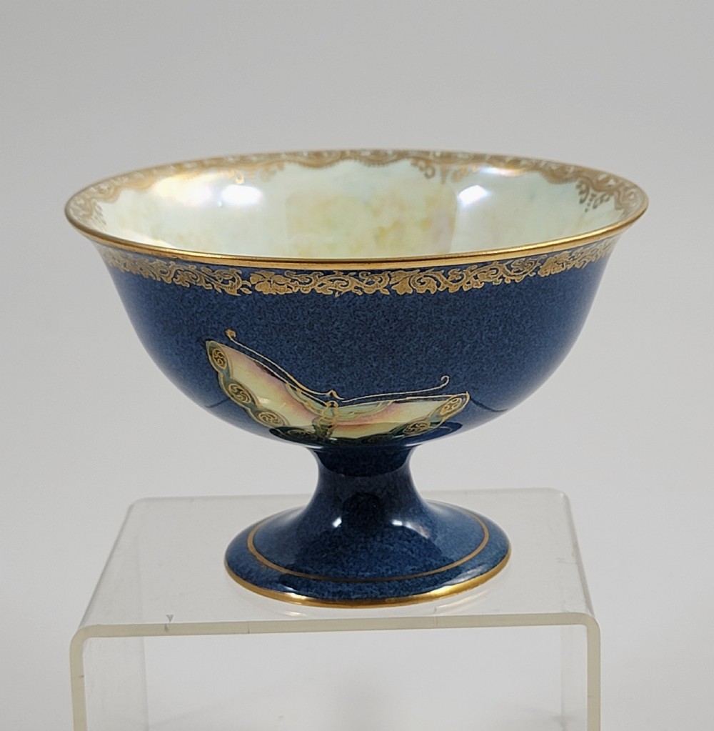 A footed Wedgwood porcelain bowl featuring a deep blue mottled exterior embellished with a gilded butterfly and an iridescent pearlescent interior with gold trim. View V
