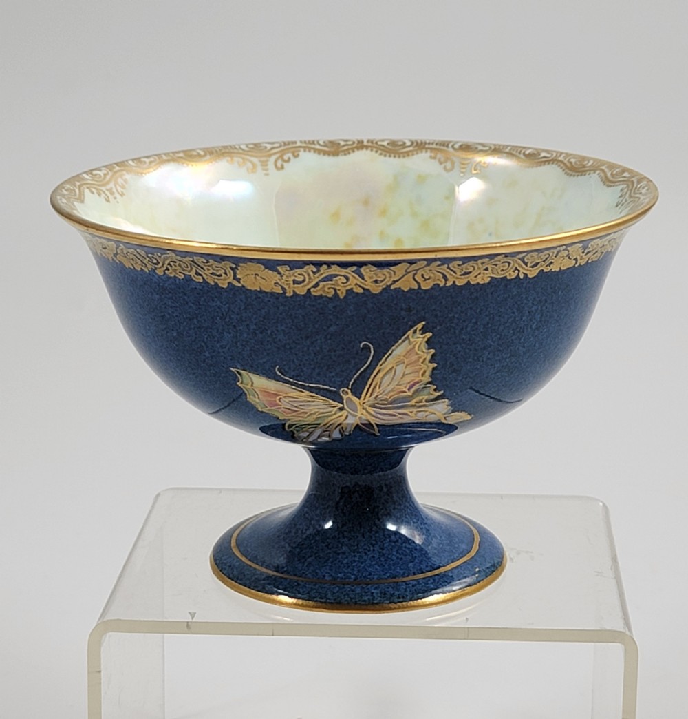 A footed Wedgwood porcelain bowl featuring a deep blue mottled exterior embellished with a gilded butterfly and an iridescent pearlescent interior with gold trim. View VII