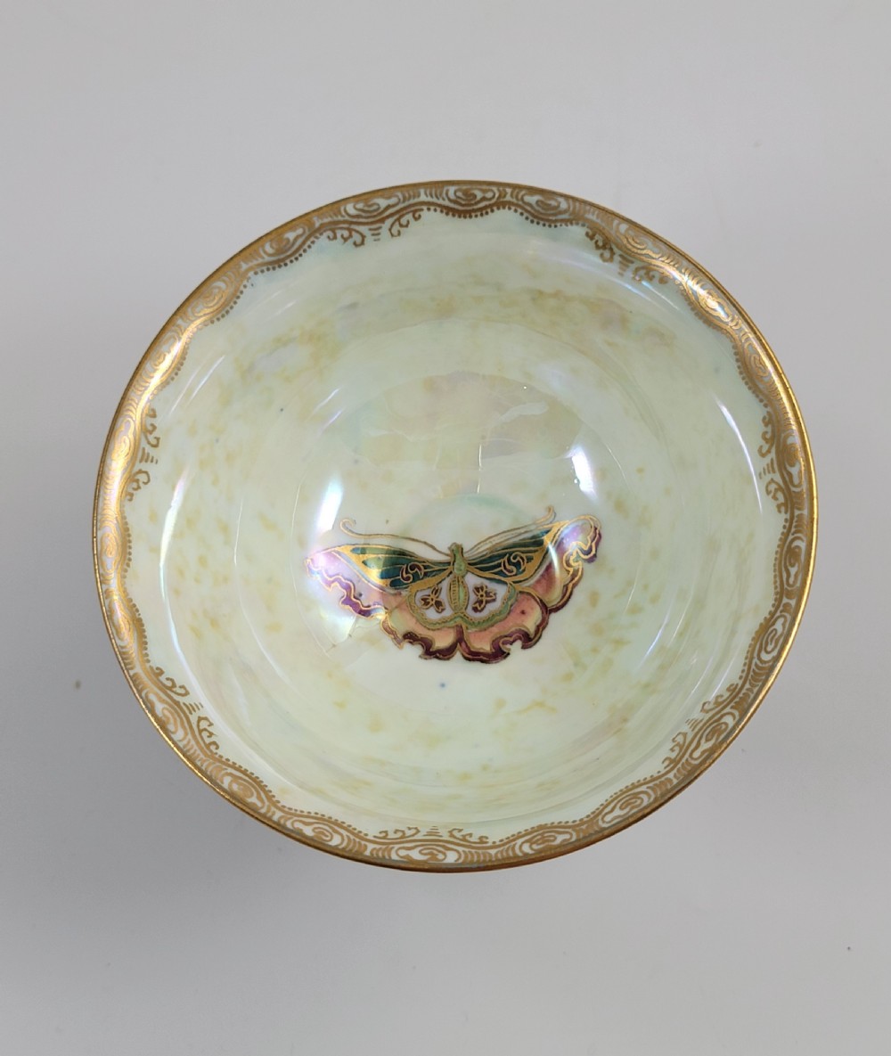 A footed Wedgwood porcelain bowl featuring a deep blue mottled exterior embellished with a gilded butterfly and an iridescent pearlescent interior with gold trim. View VIII
