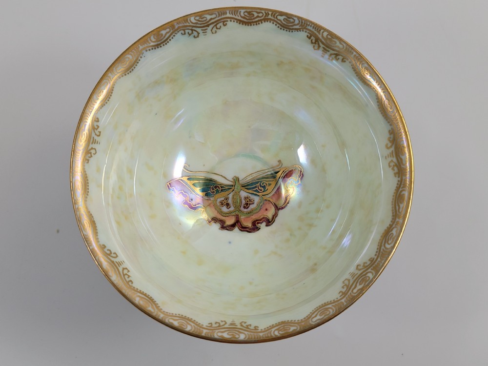 A footed Wedgwood porcelain bowl featuring a deep blue mottled exterior embellished with a gilded butterfly and an iridescent pearlescent interior with gold trim. View IX