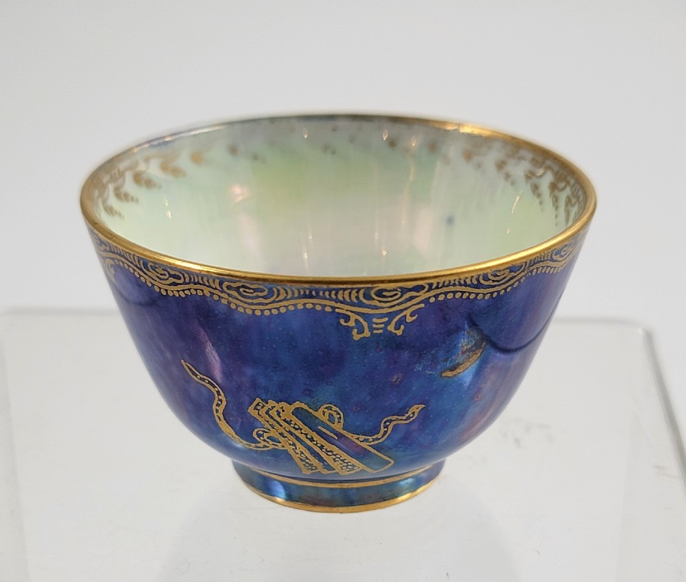 A miniature Wedgwood lustre porcelain cup featuring a cobalt blue iridescent exterior decorated with gilded dragon motifs and a pale iridescent green interior. View III