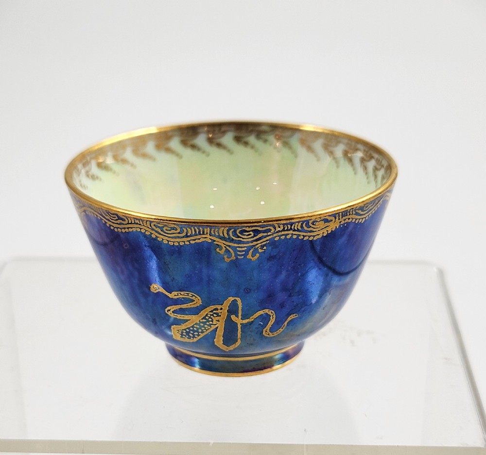 A miniature Wedgwood lustre porcelain cup featuring a cobalt blue iridescent exterior decorated with gilded dragon motifs and a pale iridescent green interior. View IV