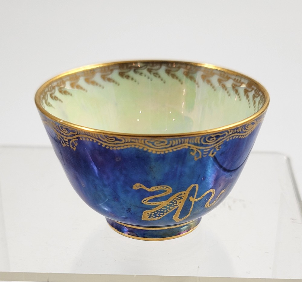 A miniature Wedgwood lustre porcelain cup featuring a cobalt blue iridescent exterior decorated with gilded dragon motifs and a pale iridescent green interior. View VI
