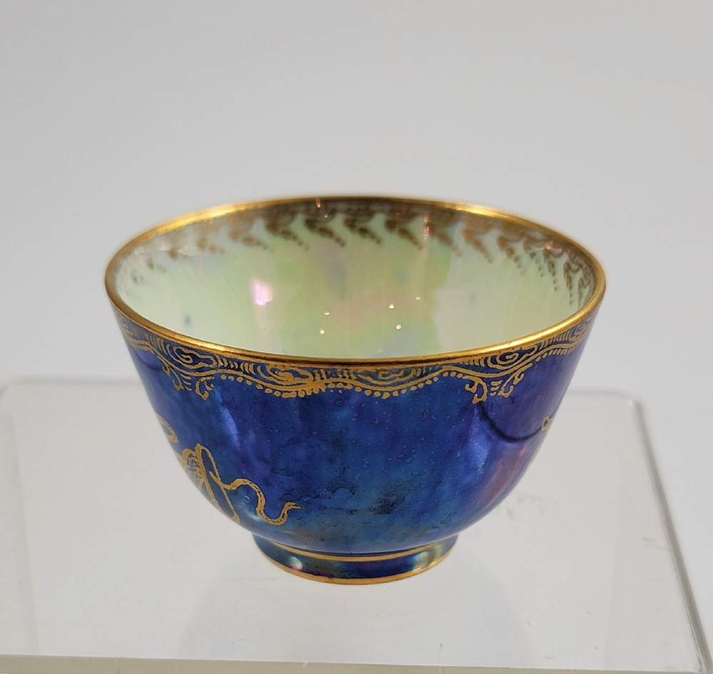 A miniature Wedgwood lustre porcelain cup featuring a cobalt blue iridescent exterior decorated with gilded dragon motifs and a pale iridescent green interior. View VII