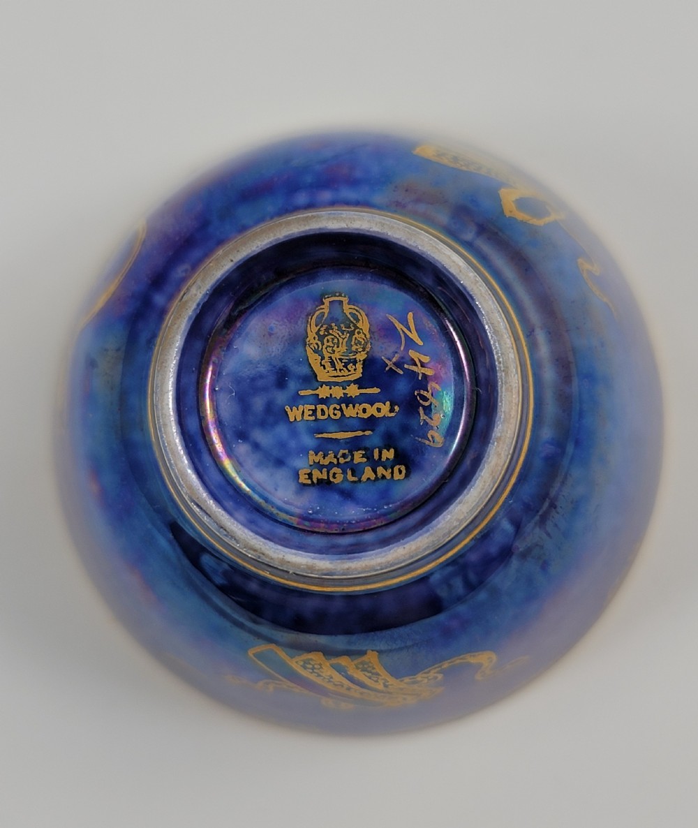 A miniature Wedgwood lustre porcelain cup featuring a cobalt blue iridescent exterior decorated with gilded dragon motifs and a pale iridescent green interior. View IX