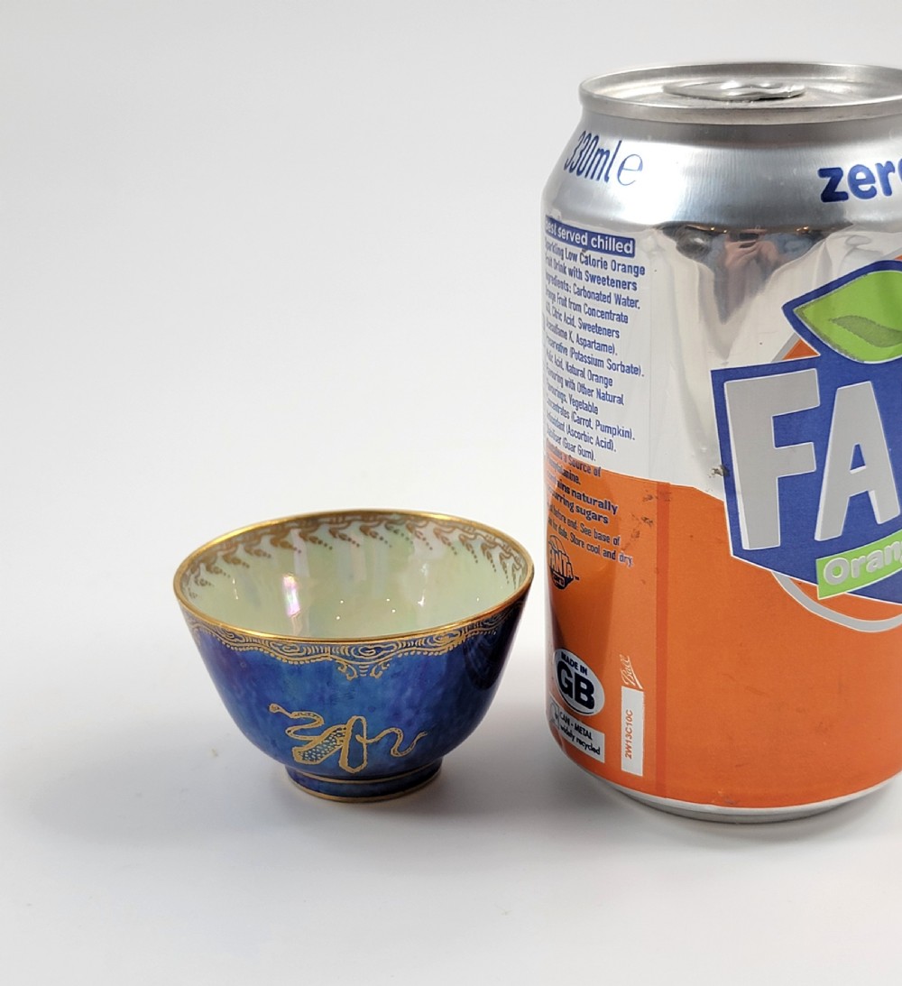 A miniature Wedgwood lustre porcelain cup featuring a cobalt blue iridescent exterior decorated with gilded dragon motifs and a pale iridescent green interior. View X