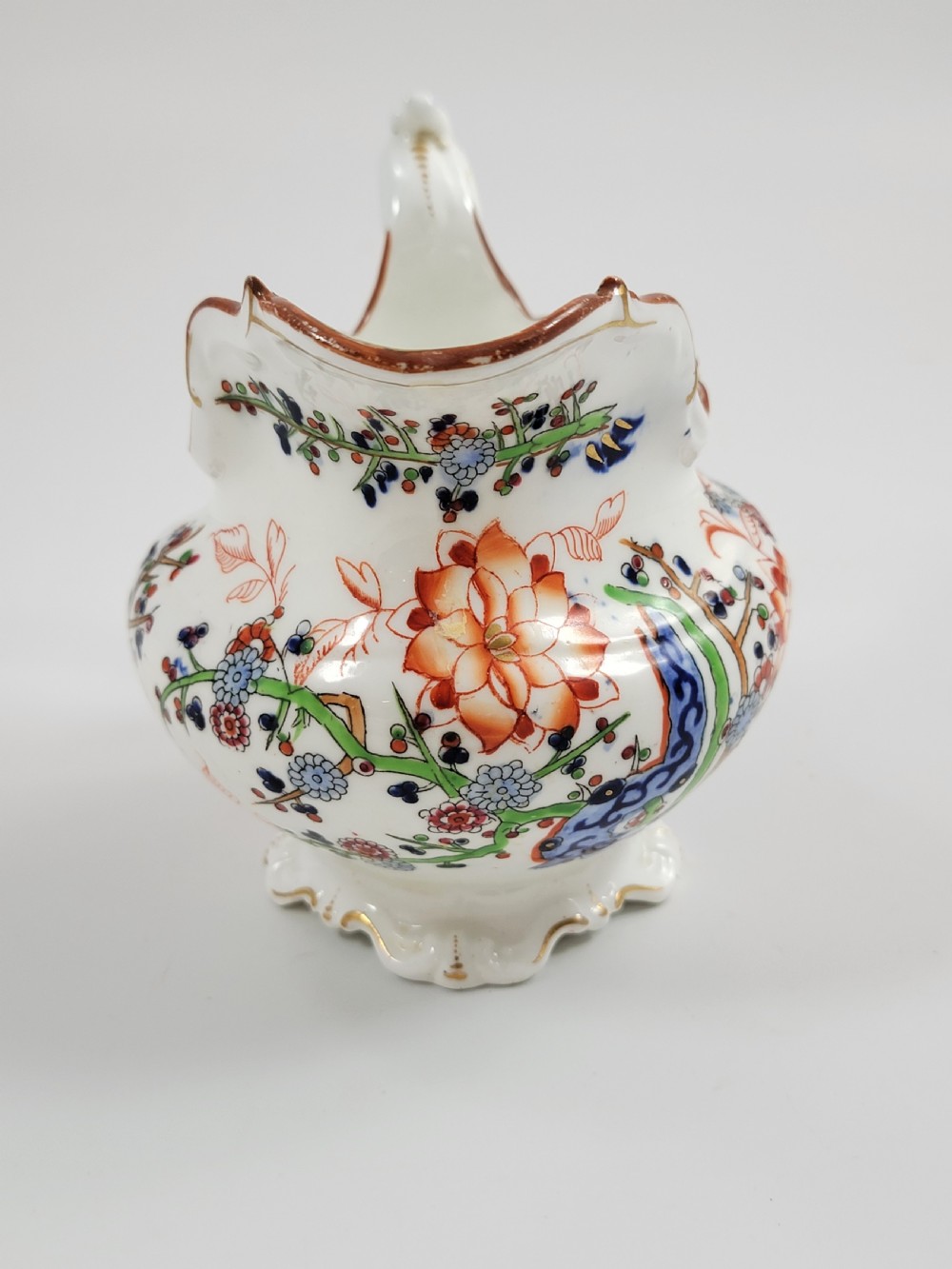 A Victorian Minton porcelain tea set featuring cups, stacked saucers, and a milk jug adorned with polychrome Kakiemon style tigers, bamboo, and flora. View VII