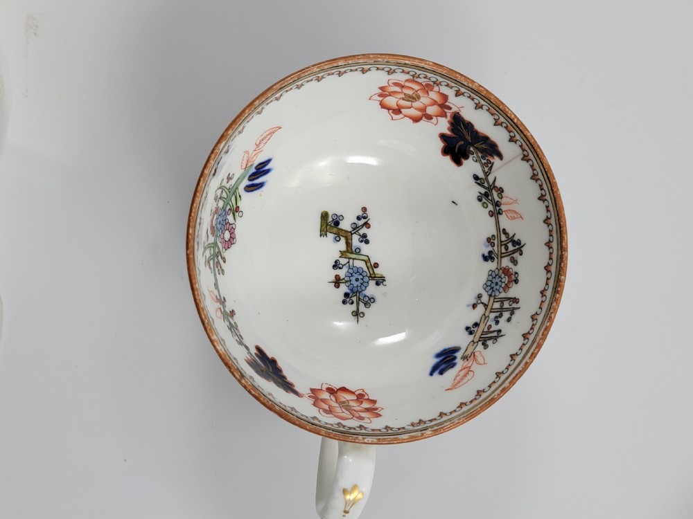 A Victorian Minton porcelain tea set featuring cups, stacked saucers, and a milk jug adorned with polychrome Kakiemon style tigers, bamboo, and flora. View XV