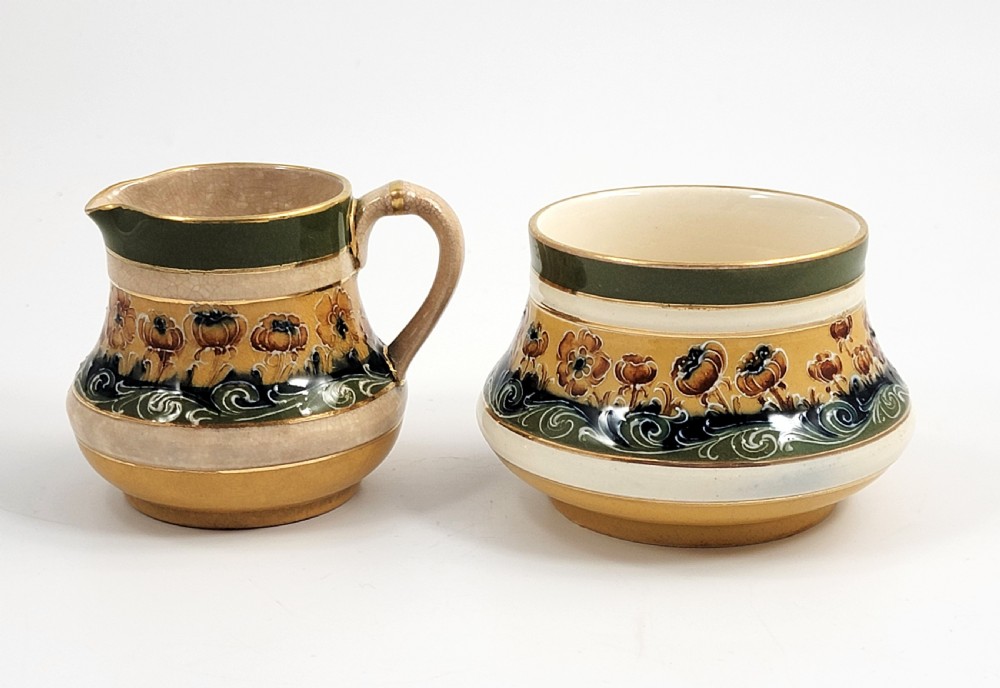 An antique four-piece Art Nouveau ceramic tea service decorated with tube-lined ochre poppy motifs and dark green glaze borders with gilded accents. View VII