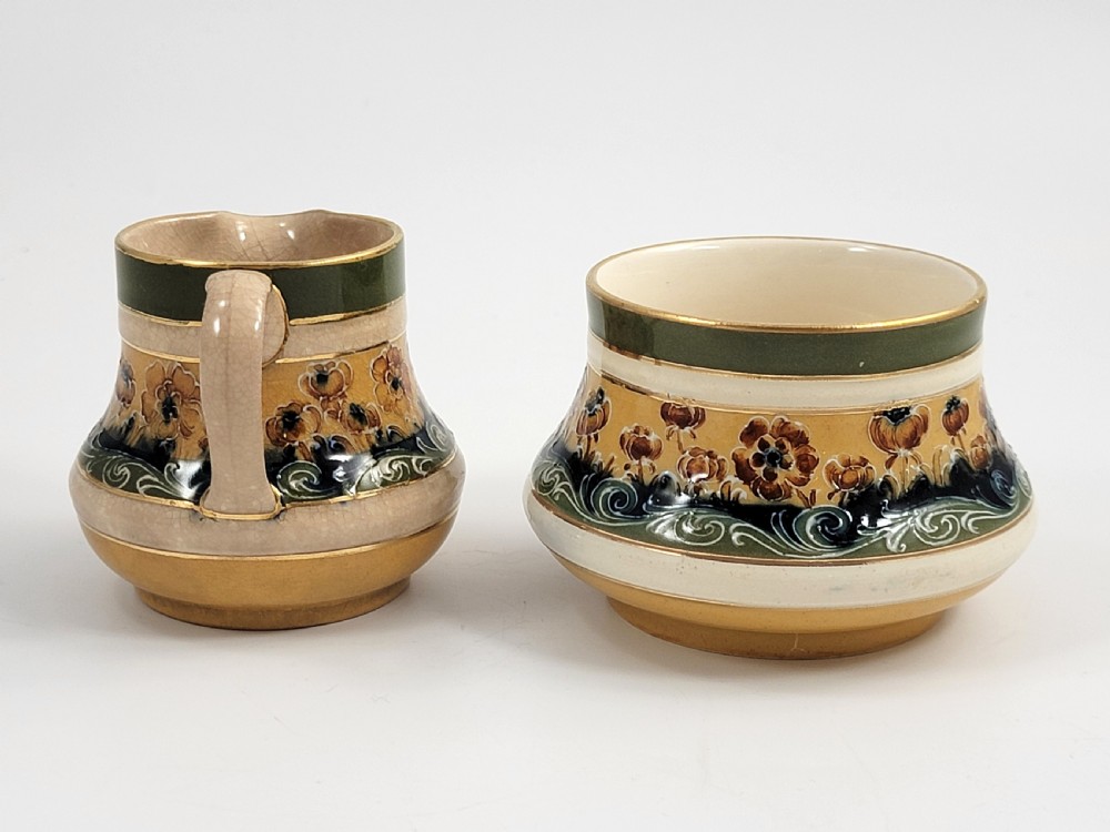 An antique four-piece Art Nouveau ceramic tea service decorated with tube-lined ochre poppy motifs and dark green glaze borders with gilded accents. View VIII