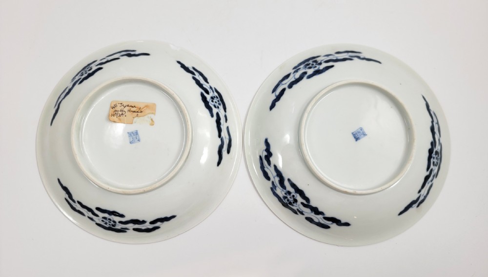 A near-pair of circular white Japanese porcelain plates decorated with hand-painted cobalt blue depictions of two koi fish. View III