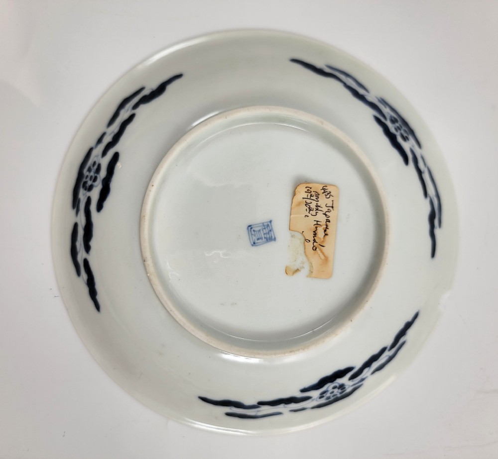 A near-pair of circular white Japanese porcelain plates decorated with hand-painted cobalt blue depictions of two koi fish. View V