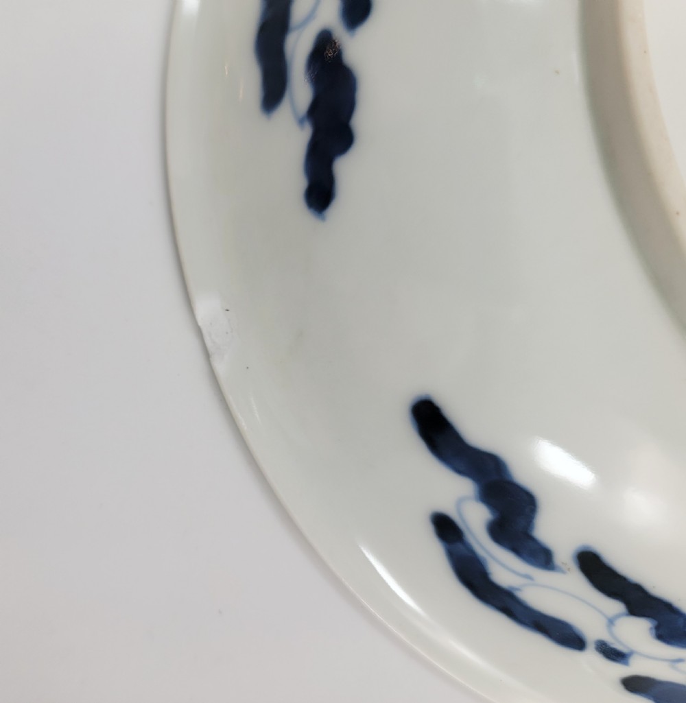 A near-pair of circular white Japanese porcelain plates decorated with hand-painted cobalt blue depictions of two koi fish. View VI