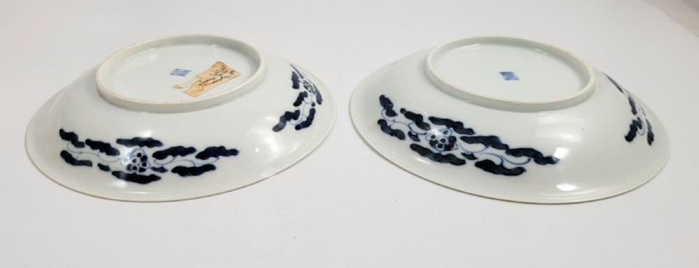 A near-pair of circular white Japanese porcelain plates decorated with hand-painted cobalt blue depictions of two koi fish. View IX