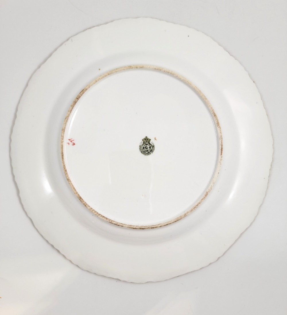 An Edwardian Royal Worcester circular porcelain cabinet plate with a cobalt blue rim decorated in heavy tooled gilding and six small floral cartouches surrounding a central hand-painted bouquet. View III