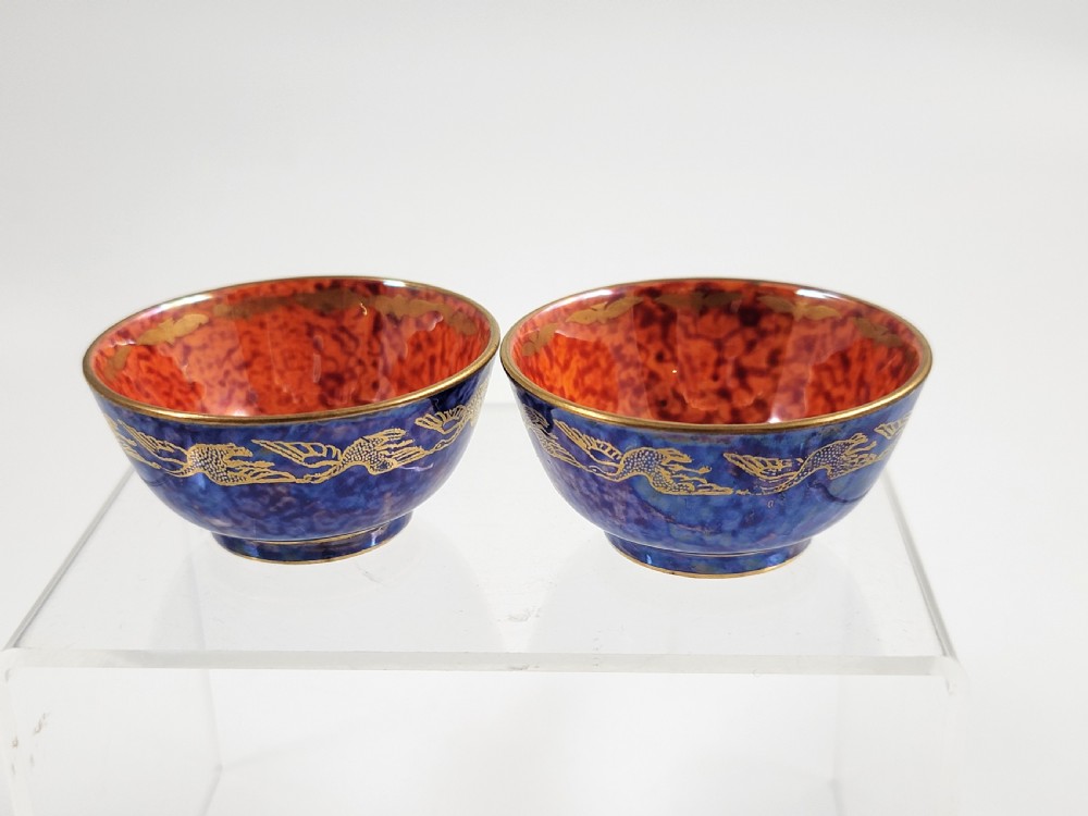 A pair of small Wedgwood lustre porcelain bowls featuring a cobalt blue exterior decorated with gilt birds and a mottled orange interior. View III
