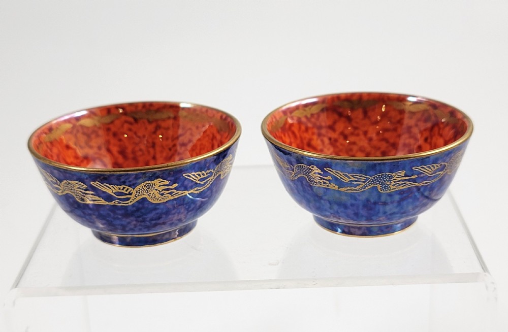 A pair of small Wedgwood lustre porcelain bowls featuring a cobalt blue exterior decorated with gilt birds and a mottled orange interior. View IV