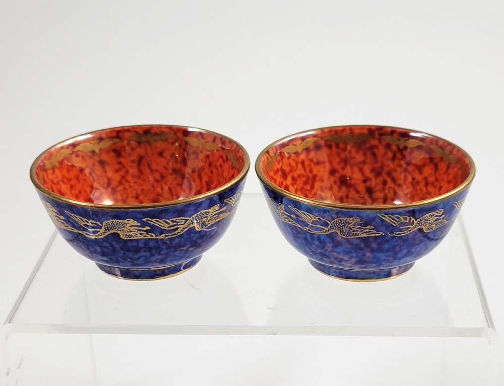A pair of small Wedgwood lustre porcelain bowls featuring a cobalt blue exterior decorated with gilt birds and a mottled orange interior. View VII