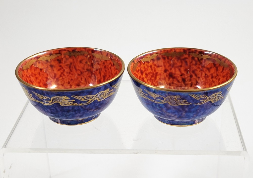 A pair of small Wedgwood lustre porcelain bowls featuring a cobalt blue exterior decorated with gilt birds and a mottled orange interior. View VIII