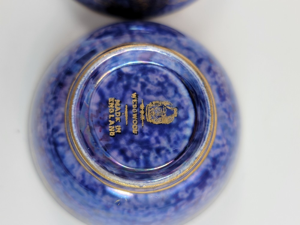 A pair of small Wedgwood lustre porcelain bowls featuring a cobalt blue exterior decorated with gilt birds and a mottled orange interior. View XI