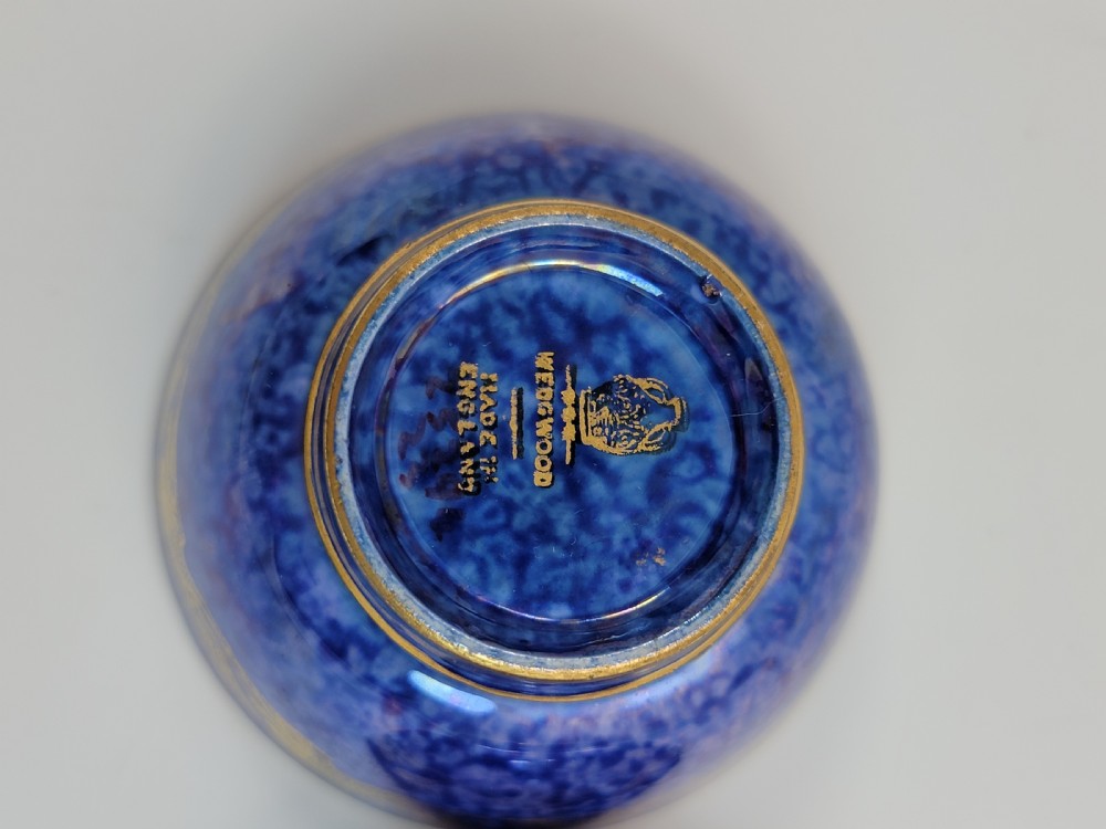 A pair of small Wedgwood lustre porcelain bowls featuring a cobalt blue exterior decorated with gilt birds and a mottled orange interior. View XII