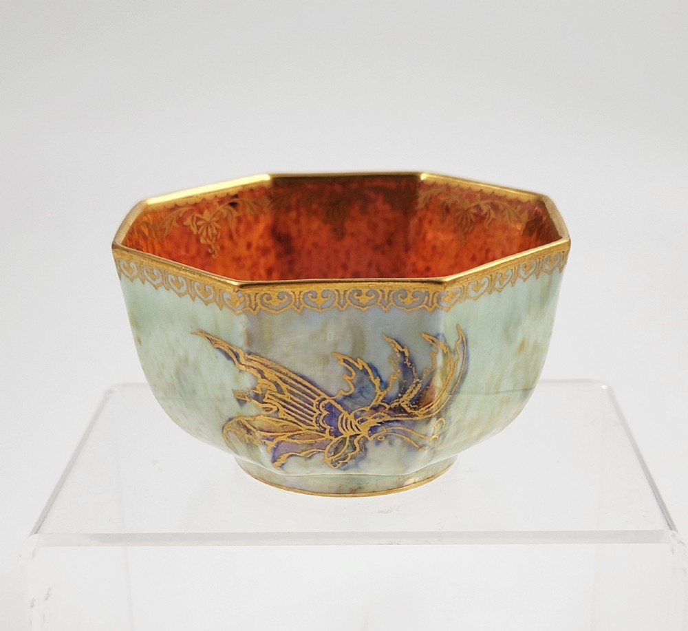 An octagonal ceramic bowl featuring a mottled pale blue and green iridescent exterior with gilt motifs and a bright orange mottled interior with gold borders. View II