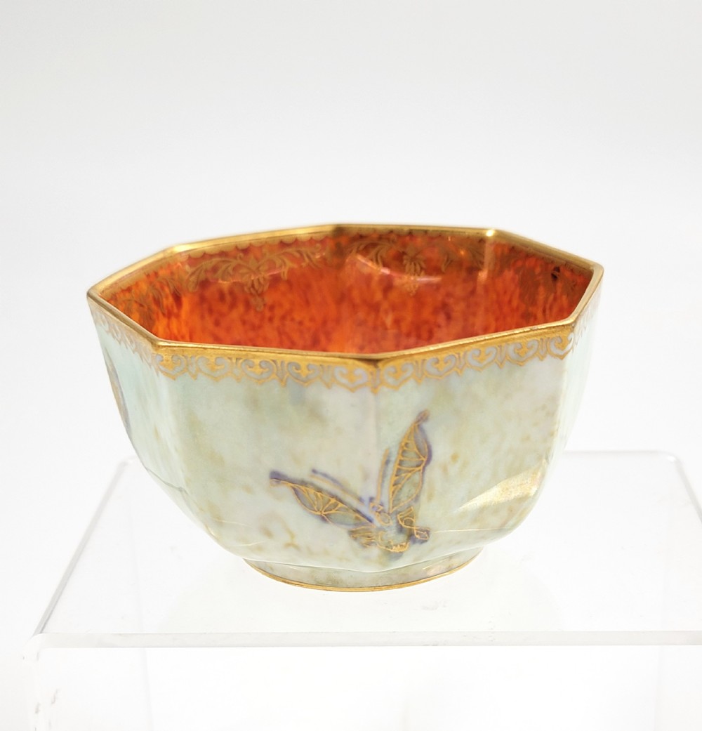 An octagonal ceramic bowl featuring a mottled pale blue and green iridescent exterior with gilt motifs and a bright orange mottled interior with gold borders. View III