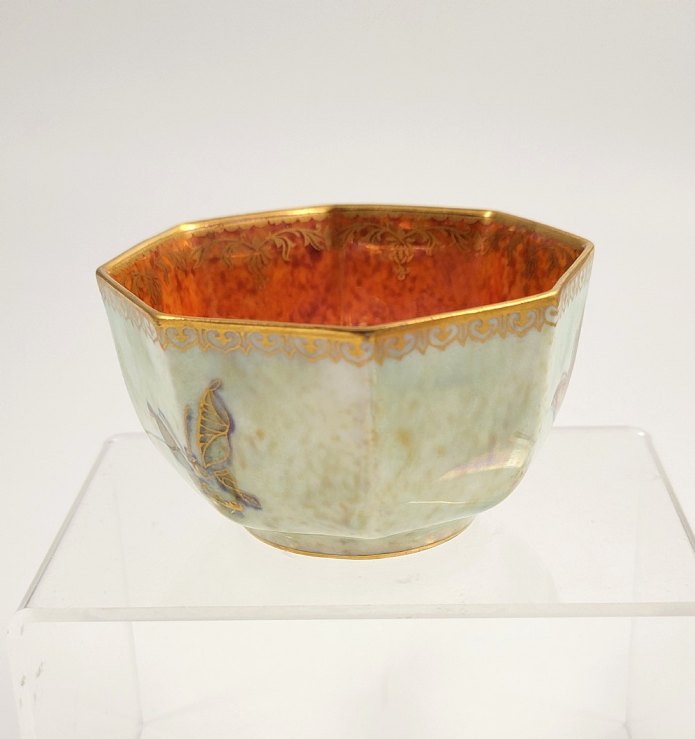 An octagonal ceramic bowl featuring a mottled pale blue and green iridescent exterior with gilt motifs and a bright orange mottled interior with gold borders. View IV