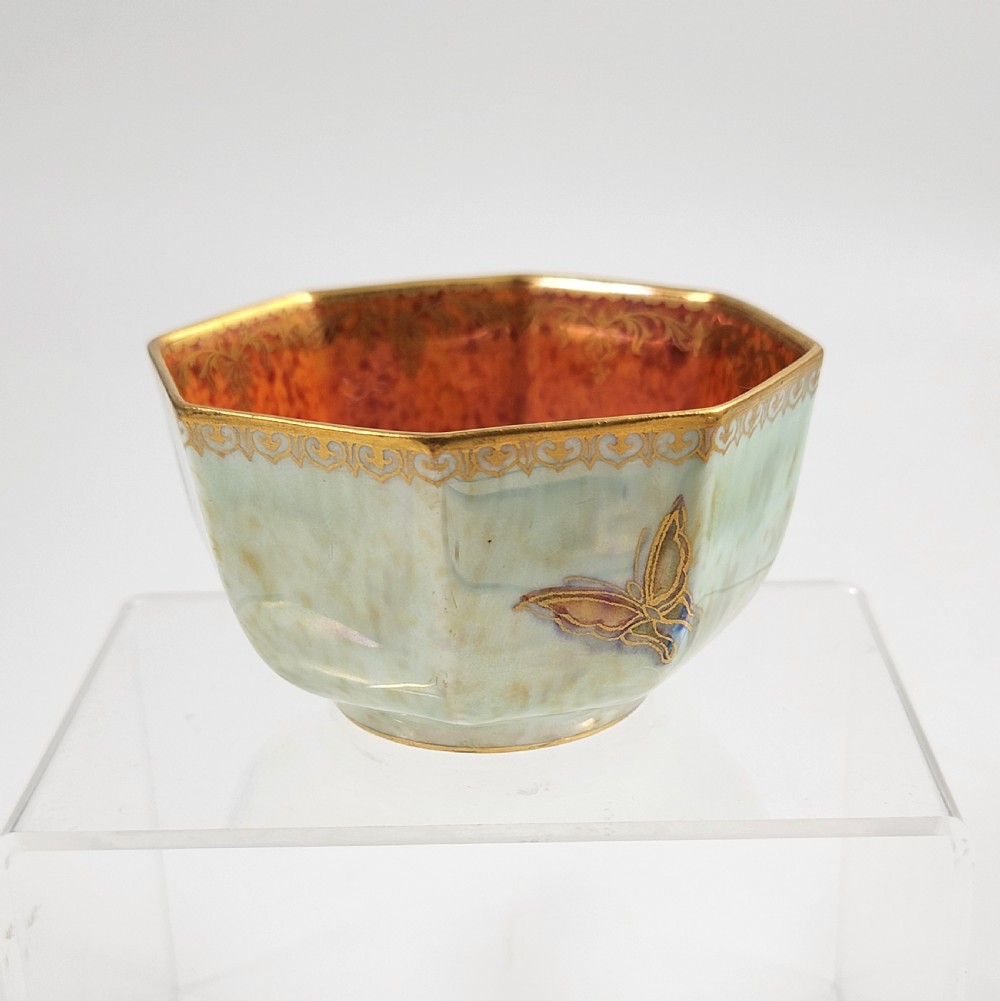 An octagonal ceramic bowl featuring a mottled pale blue and green iridescent exterior with gilt motifs and a bright orange mottled interior with gold borders. View V