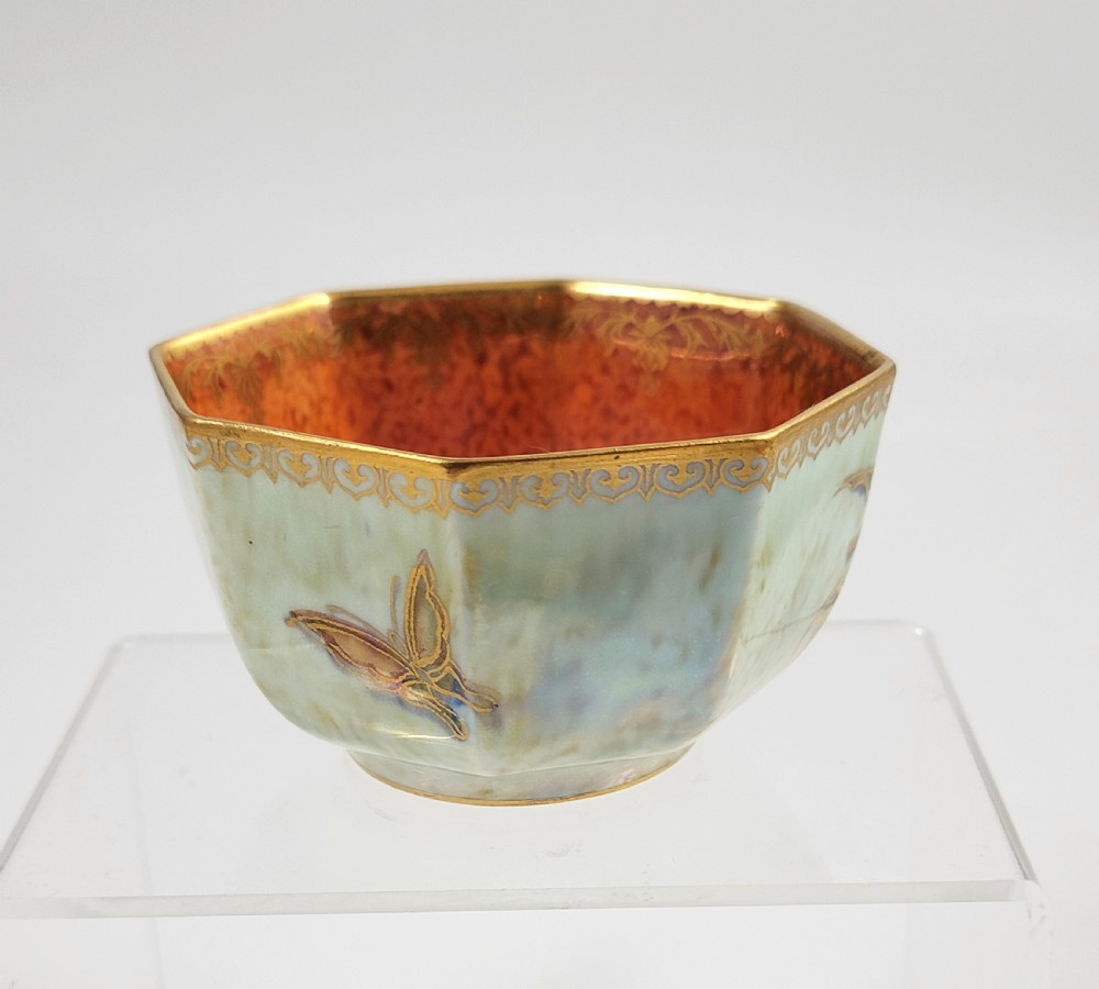 An octagonal ceramic bowl featuring a mottled pale blue and green iridescent exterior with gilt motifs and a bright orange mottled interior with gold borders. View VI