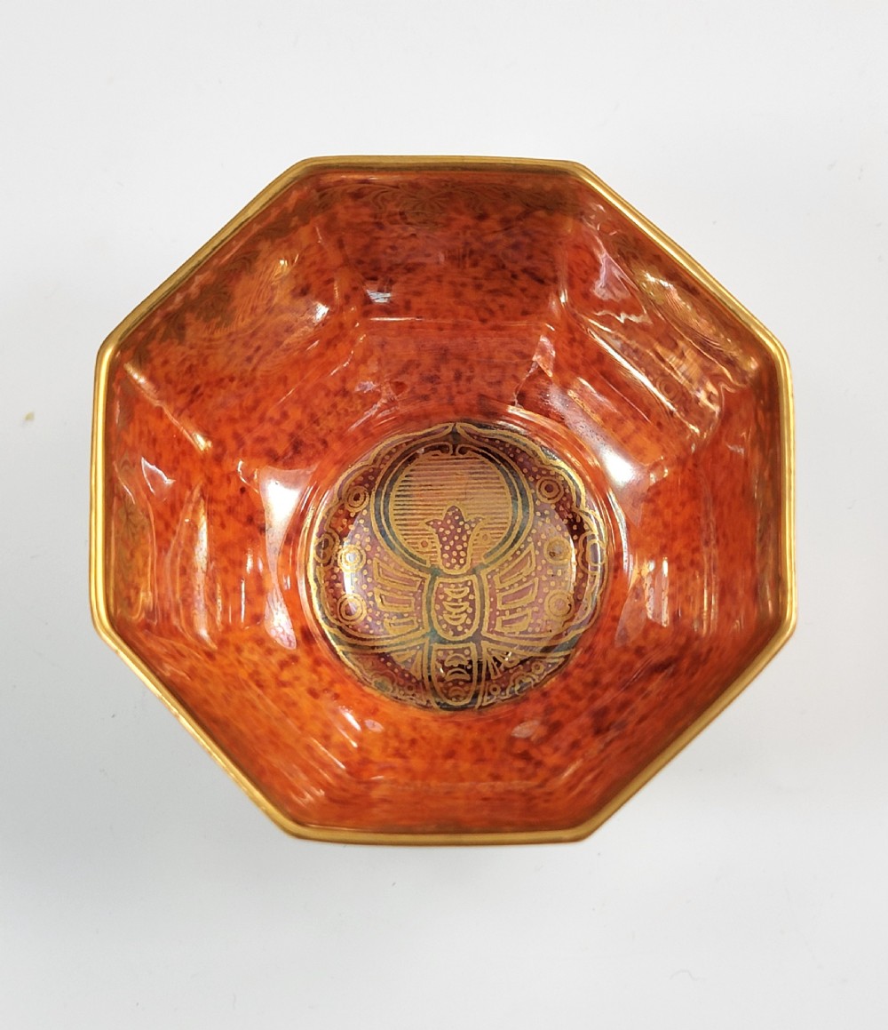 An octagonal ceramic bowl featuring a mottled pale blue and green iridescent exterior with gilt motifs and a bright orange mottled interior with gold borders. View VIII