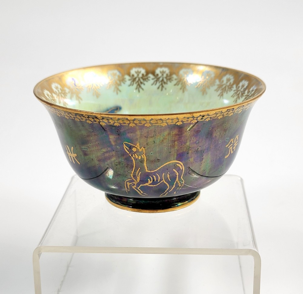 An antique footed porcelain bowl featuring iridescent purple and green glazes decorated with gilt dragons and ornamental borders. View V