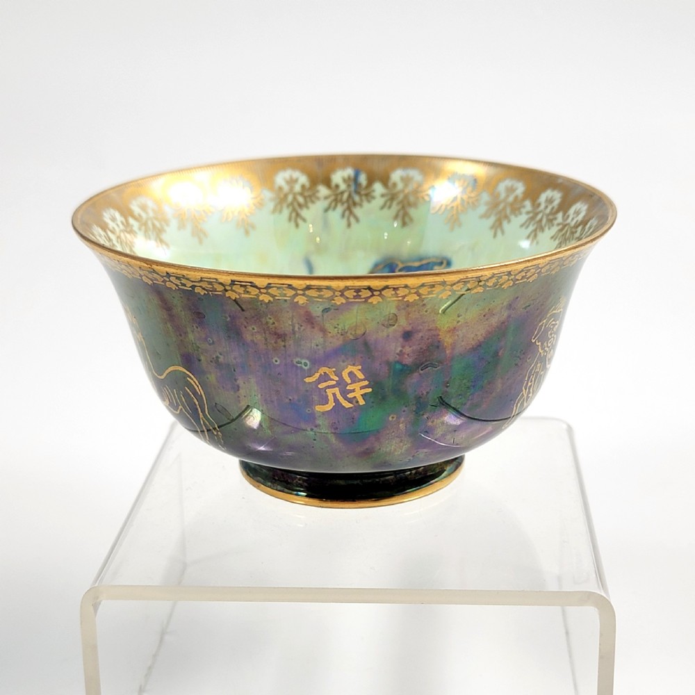 An antique footed porcelain bowl featuring iridescent purple and green glazes decorated with gilt dragons and ornamental borders. View VI