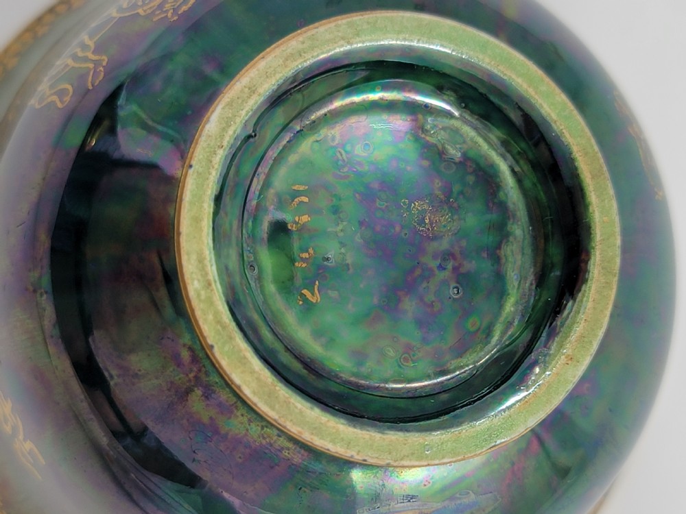 An antique footed porcelain bowl featuring iridescent purple and green glazes decorated with gilt dragons and ornamental borders. View VIII