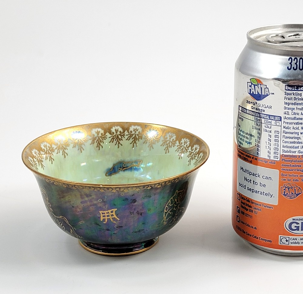 An antique footed porcelain bowl featuring iridescent purple and green glazes decorated with gilt dragons and ornamental borders. View IX