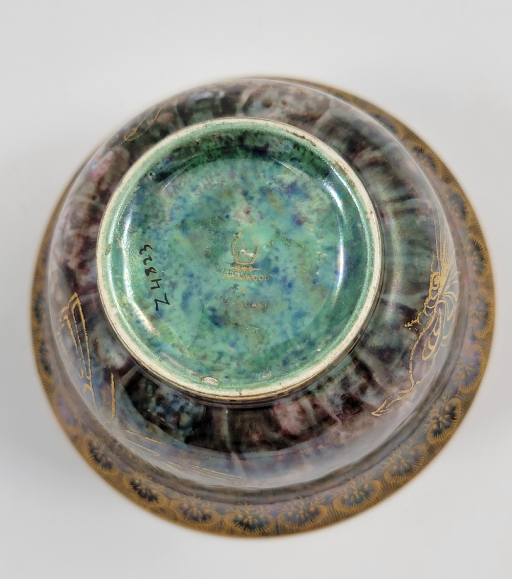 A circular porcelain bowl featuring a mottled iridescent purple exterior decorated with gilt butterfly motifs and a gold-toned orange interior. View VII