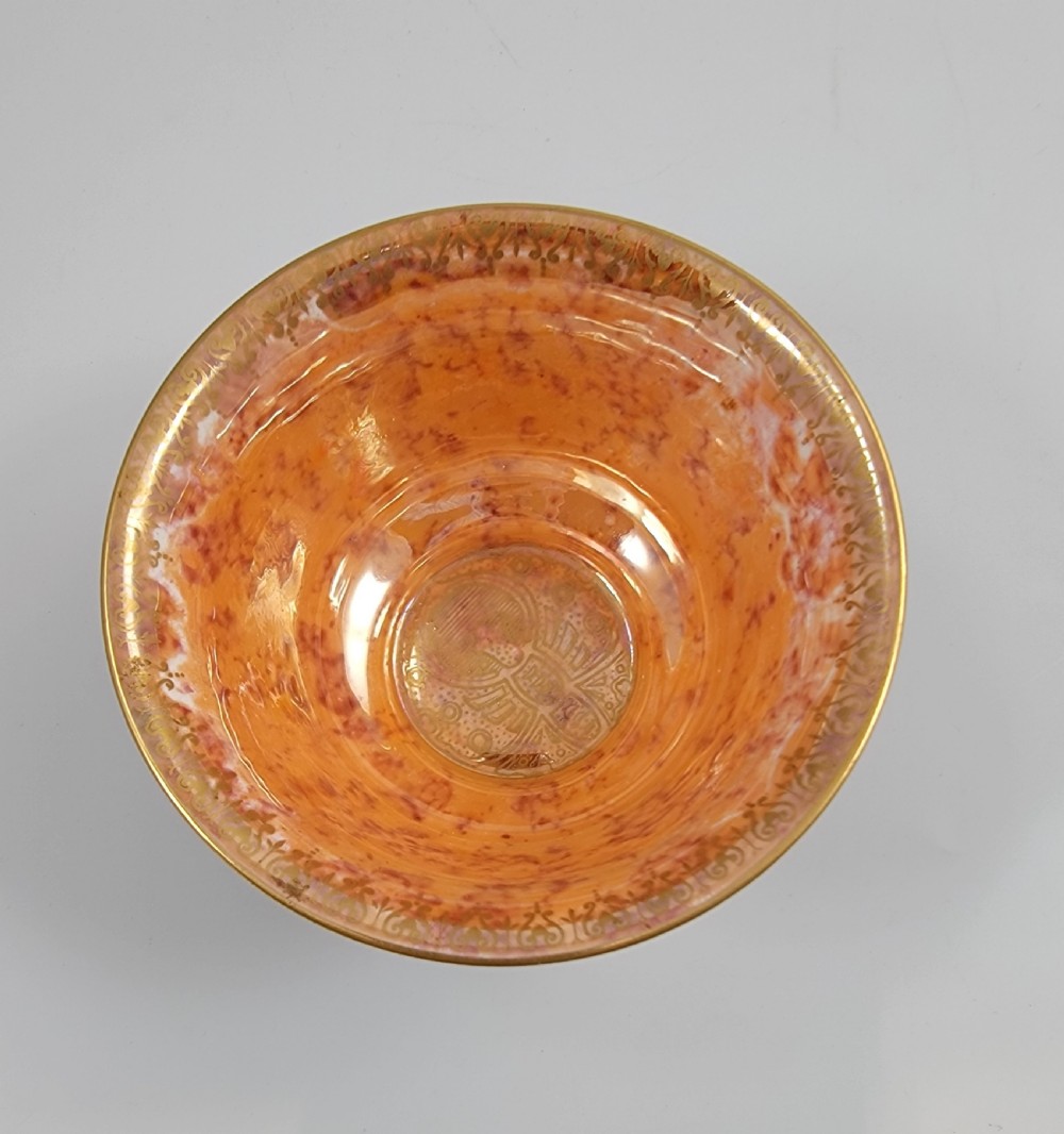 A circular porcelain bowl featuring a mottled iridescent purple exterior decorated with gilt butterfly motifs and a gold-toned orange interior. View IX