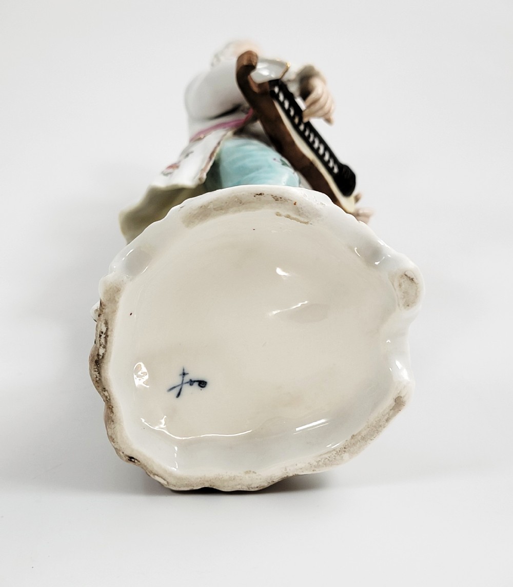 A Samson of Paris porcelain figure depicting an eighteenth-century male musician holding a hurdy-gurdy, decorated with hand-painted floral motifs and gilding. View VIII